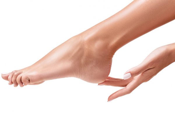 Perfect soft female feet isolated on white background. Spa, scrub and foot care concept.